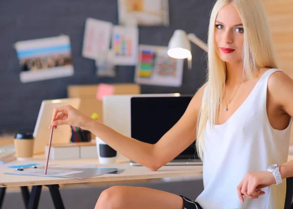 Modedesigner, die im Atelier arbeiten, sitzen am Schreibtisch — Stockfoto