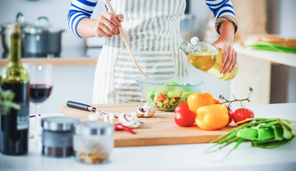 Glimlachende jonge vrouw mengen van verse salade — Stockfoto