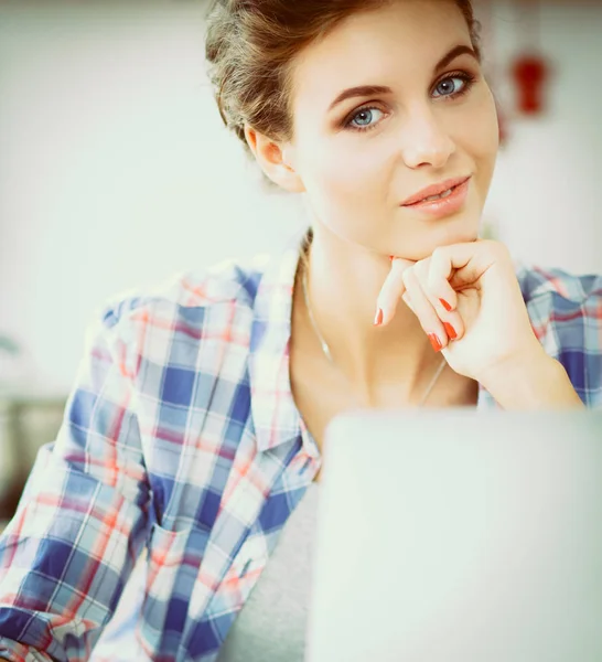 Lachende vrouw online winkelen met behulp van computer en creditcard in de keuken — Stockfoto