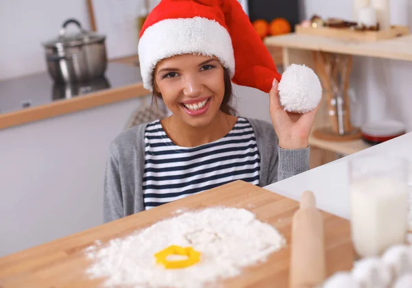 幸せな若い女性笑顔幸せを持って楽しみますクリスマスの準備を身に着けているサンタの帽子 — ストック写真