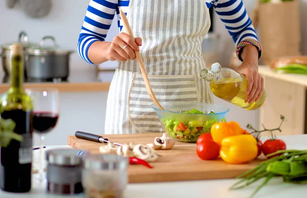 Jeune femme mélangeant salade fraîche — Photo