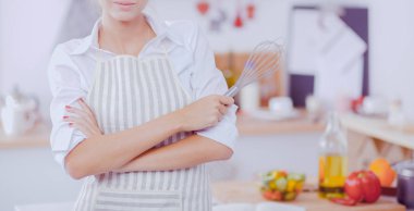 Noel arka plan üzerinde duran mutfakta gülümseyen genç kadın