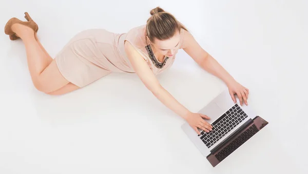 Donna con un computer portatile sdraiato sul pavimento — Foto Stock