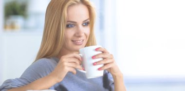 evde kanepenin üzerine bir fincan genç güzel kadın