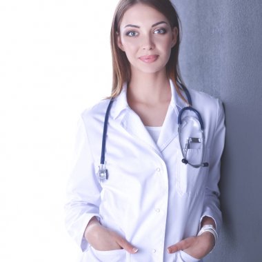 Steteskobu olan doktor kadın gri arka planda izole edilmiş.