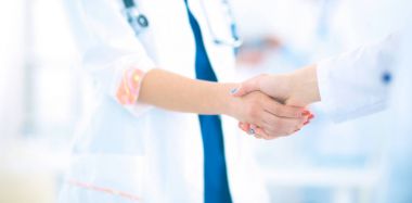 Genç tıpçılar ofiste el sıkışıyor.