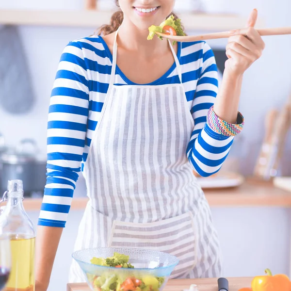 Giovane donna mangiare insalata fresca in cucina moderna — Foto Stock