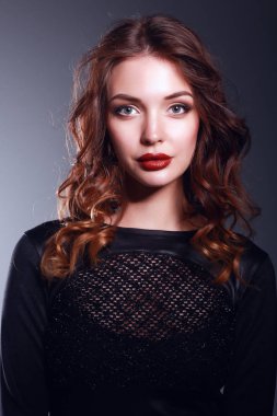 Siyah elbiseli, akşam makyajlı güzel bir kadın.