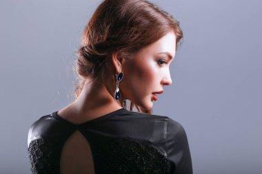 Siyah elbiseli, akşam makyajlı güzel bir kadın.