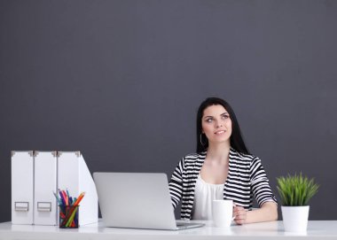 Dizüstü bilgisayar ile onun masasında çalışan güzel kadın