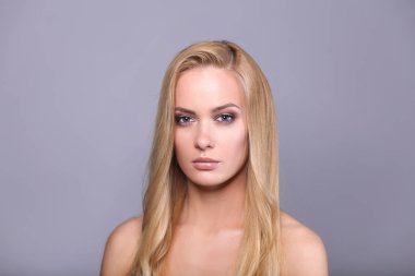 Gri arka planda izole edilmiş güzel bir kadının portresi.