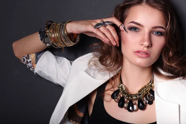 Portrait of young woman with beads, standing on black background — Stock Photo, Image