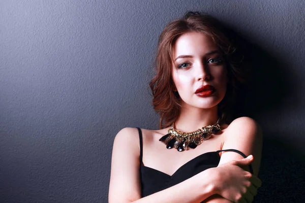 Hermosa mujer con maquillaje de noche en vestido negro — Foto de Stock