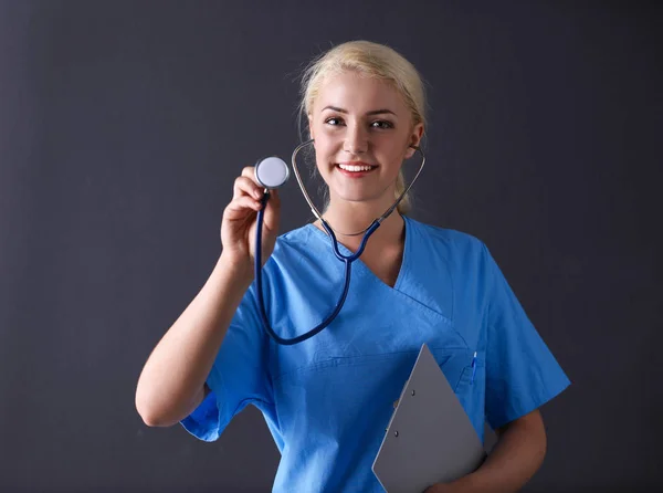 Ženský lékař se stetoskopem poslech, izolované na šedém pozadí — Stock fotografie