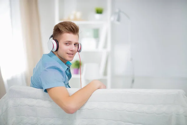 Homem ouvindo música com fones de ouvido em casa — Fotografia de Stock