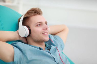 Adam evde kulaklık ile müzik dinleme