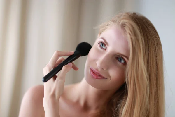 Bella donna applicando make up con pennello — Foto Stock