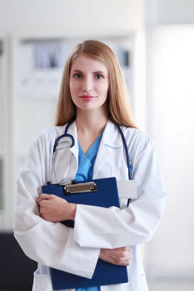 Portrait of woman doctor with folder at hospital corridor — Stock Photo, Image