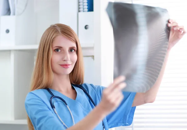Młody lekarz kobieta, patrząc na zdjęcie rentgenowskie — Zdjęcie stockowe