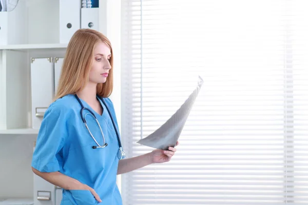 Young female doctor looking at the x-ray picture — Stock Photo, Image