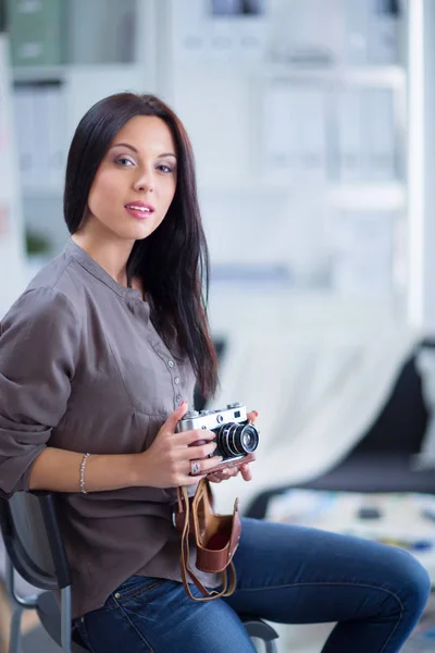 Fotografka sedící na stole s laptopem — Stock fotografie