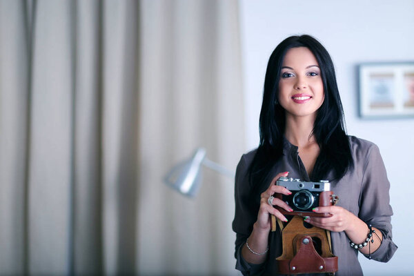 Женщина-фотограф сидит на столе с ноутбуком