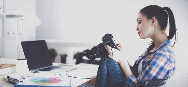 Vrouwelijke fotograaf zittend op het bureau met laptop — Stockfoto