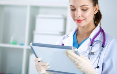 Kadın doktor hastanede dosyayla bekliyor.