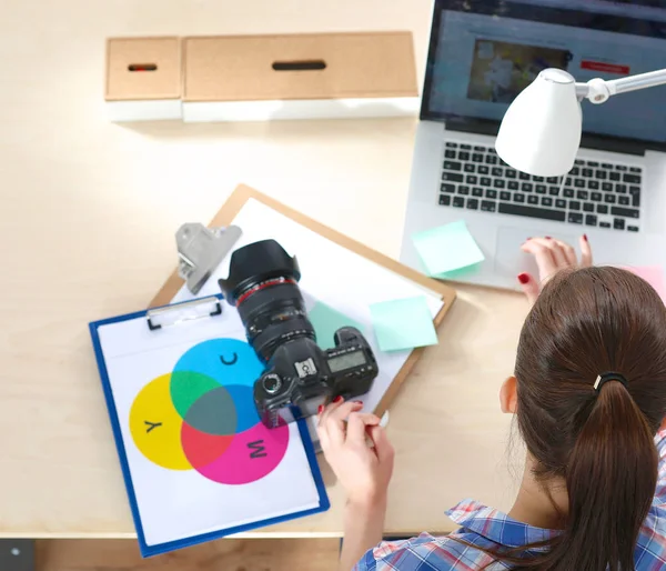 Female photographer sitting on the desk with laptop — Stock Photo, Image