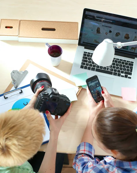 Due fotografe sedute sulla scrivania con computer portatile — Foto Stock