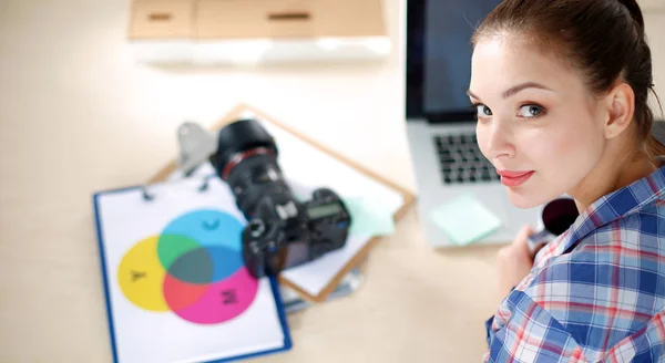 Kvinnlig fotograf sitter på skrivbordet med bärbar dator — Stockfoto