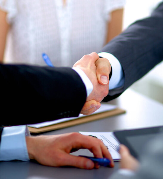 Деловые люди пожимают друг другу руки, заканчивают встречу
