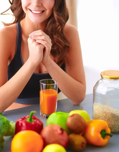 Menina sentada na cozinha na mesa com frutas e óculos com suco — Fotografia de Stock