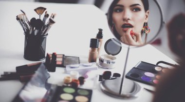 Genç güzel kadın ayna, Masa başında oturan yakınındaki makyaj yapma