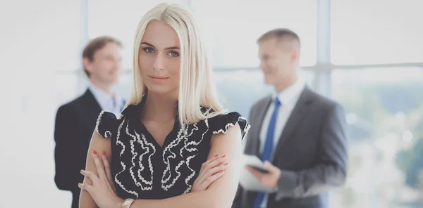 Affärskvinna som står i förgrunden i office — Stockfoto