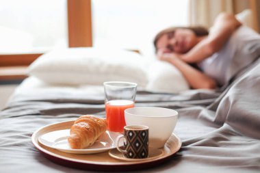 bir bardak süt ile yatakta oturan genç kadın