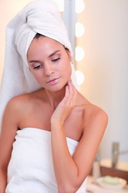 Banyo aynası önünde duran genç çekici kadın