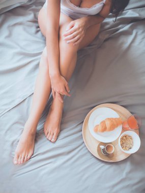 bir bardak süt ile yatakta oturan genç kadın