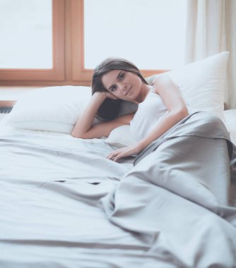 Evdeki yatakta uzanmış güzel esmer