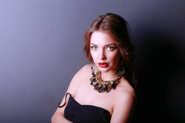 Siyah elbiseli, akşam makyajlı güzel bir kadın.