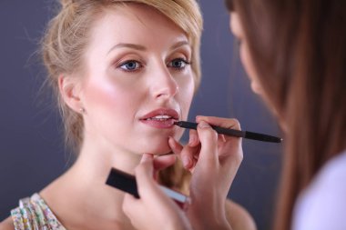 Kadından profesyonel makyaj yapan sanatçı.