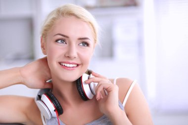 Evdeki genç ve güzel kadın kanepede oturup müzik dinliyor.