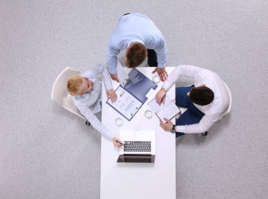 İş adamları toplantıda, ofiste oturup tartışıyorlar.