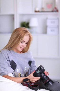 nő ül a kanapén házában a kamera