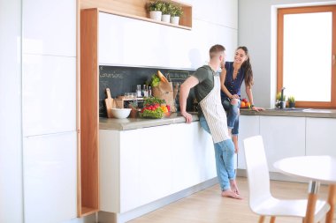 Güzel genç çift evde mutfakta eğleniyor.