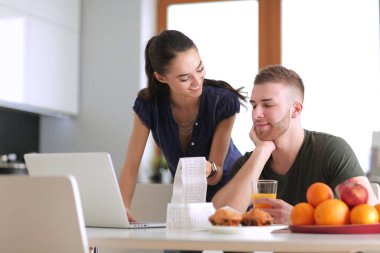 Çift evde mutfak içinde laptop ile onların fatura ödeme