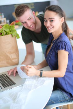 Çift evde mutfak içinde laptop ile onların fatura ödeme