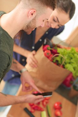 Mutlu çift Smartphone ayakta mutfakta kullanarak