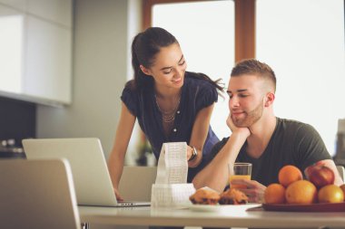 Çift evde mutfak içinde laptop ile onların fatura ödeme