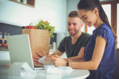 Çift evde mutfak içinde laptop ile onların fatura ödeme